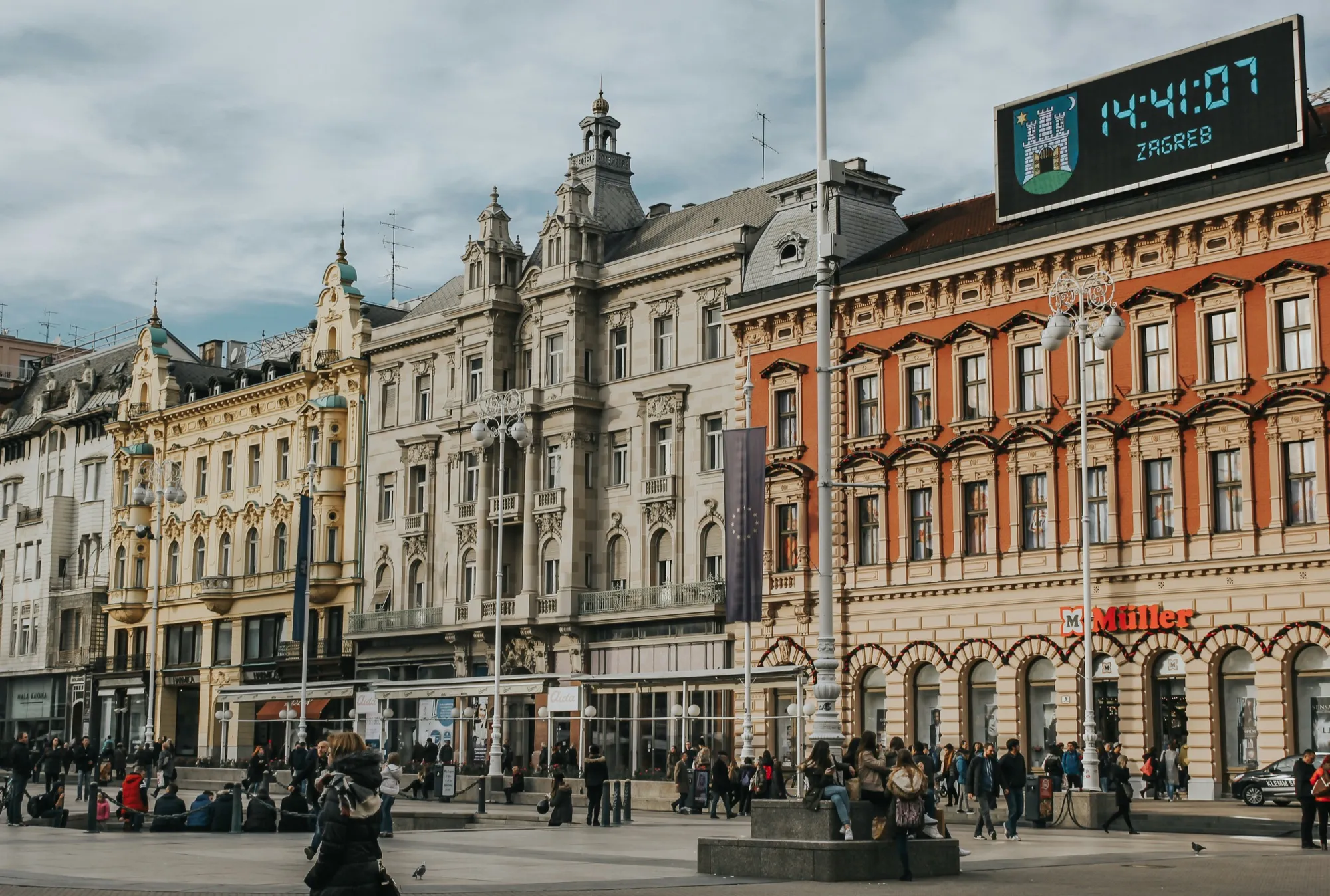 Ban Jelačić Square in Zagreb: ornate nineteenth-century façades and the city clock above the crowd