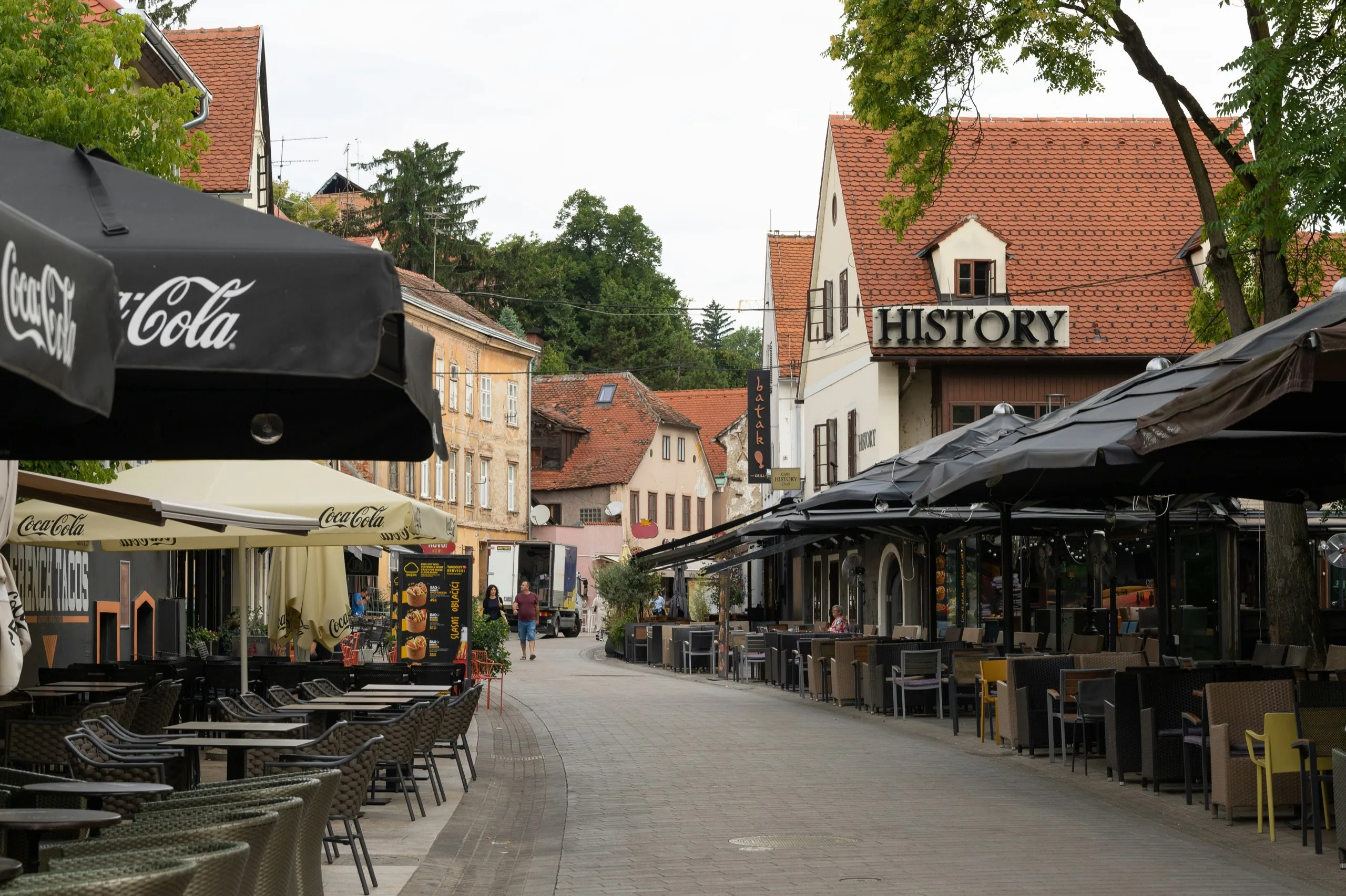 Café terraces and pastel townhouses lining Tkalčićeva street in Zagreb on a quiet morning